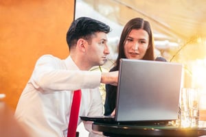 Man showing a woman his computer screen